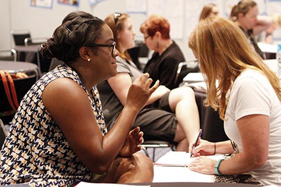 A picture of two teachers collaborating and taking notes