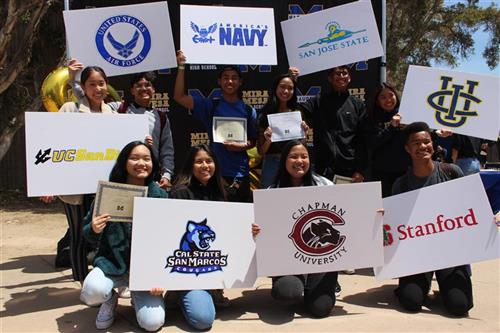 students holding college signs 